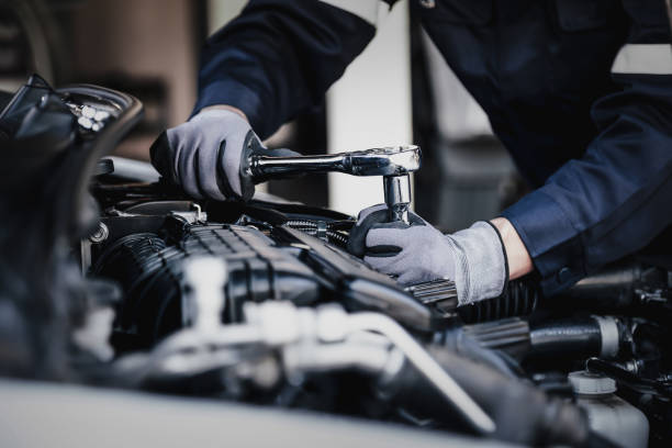 Professional mechanic working on the engine of the car in the garage. Car repair service. The concept of checking the readiness of the car before leaving.